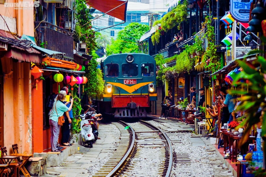 Train passing through Hanoi Train Street with cafes and tourists – Auasia Travel